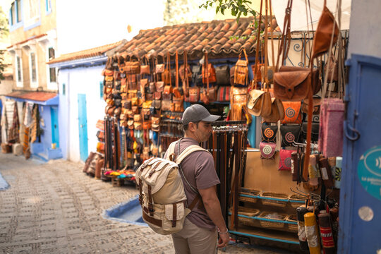 Man stopping to look at items outside a shop in Chefchaouen