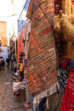 Colorful rugs hanging on a blue street in Chefchaouen