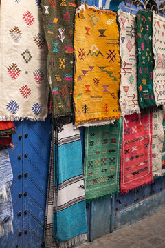 Colorful rugs hanging on a blue street in Chefchaouen