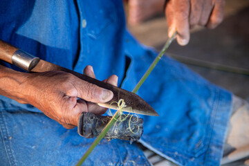 Senior artisan shaping bamboo for traditional craft