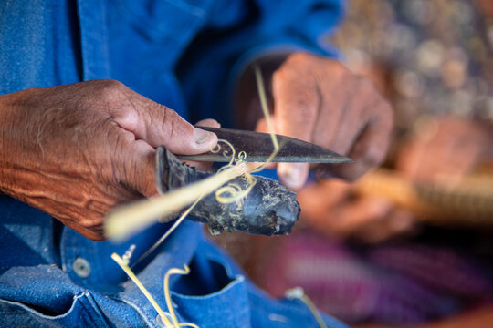 Senior artisan shaping bamboo for traditional craft