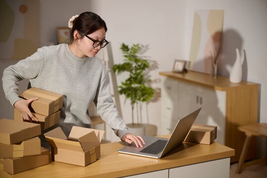 Young woman working from home, packing and shipping online orders