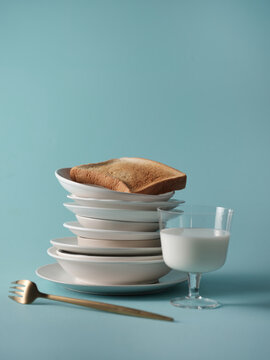 Breakfast still life with toast, milk, and a fork on a blue background