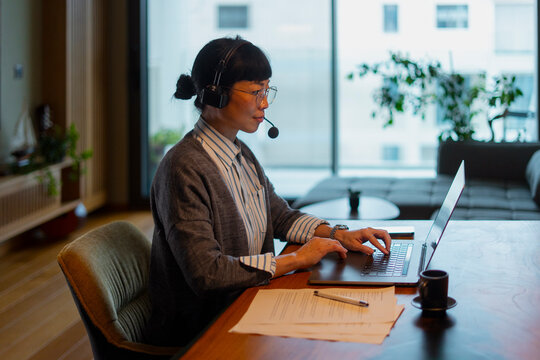 Woman teleworking remotely, engaging in online customer support
