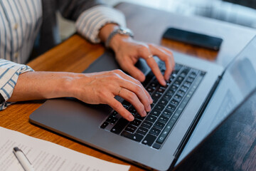 Person typing on laptop keyboard for remote work
