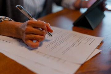 Person signing legal document finalizing business agreement
