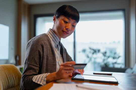 Asian woman online shopping using credit card and tablet
