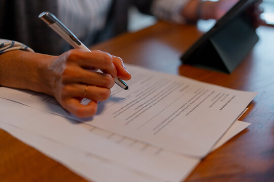 Person signing legal document finalizing business agreement

