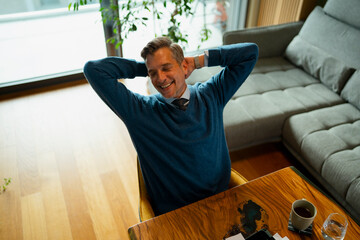 Happy man relaxing smiling at home office desk
