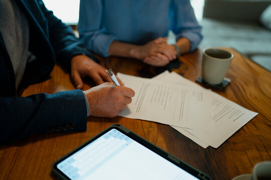 Man signing contract document with financial advisor
