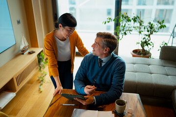 Mature couple discussing financial planning using digital tablet at ho