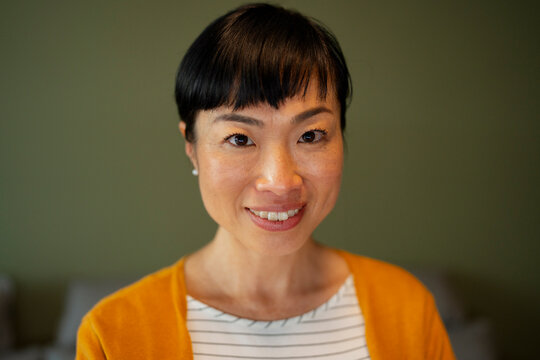 Smiling asian woman standing for a headshot portrait
