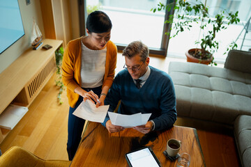 Couple discussing financial planning documents at home
