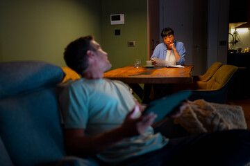 Couple experiencing financial stress at home studying documents
