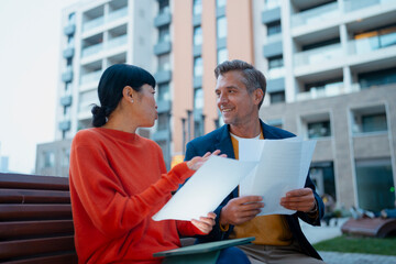 Business colleagues having meeting and discussing documents outdoor
