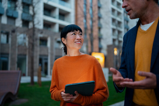 Colleagues having a business discussion with tablet outdoors
