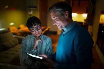 Colleagues collaborating on tablet with mentor in office
