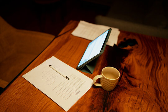 Desktop workspace with contract, tablet, pen, and coffee
