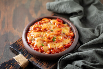 Karides guvec. Turkish cuisine. Baked shrimps with vegetables, tomato sauce and melted cheese