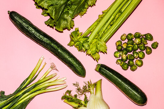 Green vegetables on a pink surface