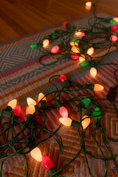 Colorful String Christmas Lights Arranged on a Patterned Rug