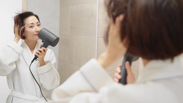 ドライヤーで髪を乾かしている女性　ビューティイメージ