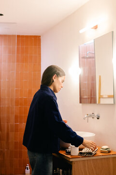 Woman carrying out her morning skincare steps in the bathroom