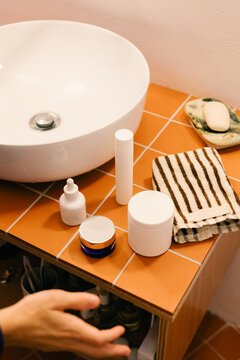 Woman's skincare and personal care products arranged on a sink