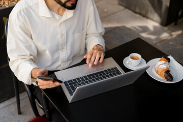 A man working with his laptop in a cafe