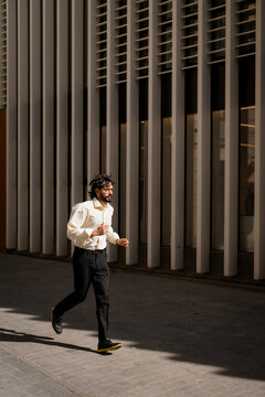 A man runs down the street because he's late at the office.