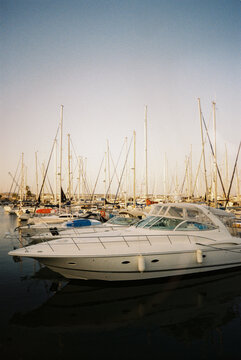 Luxury yachts docked in marina at sunset
