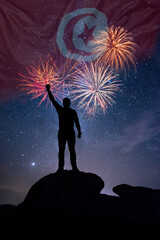 Man against background of a fireworks and national flag of Tunisia