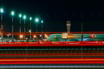 Night Aircraft on Tarmac with Traffic Light Trails