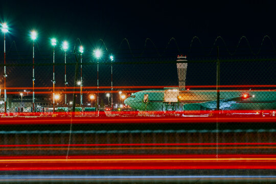 Night Aircraft on Tarmac with Traffic Light Trails