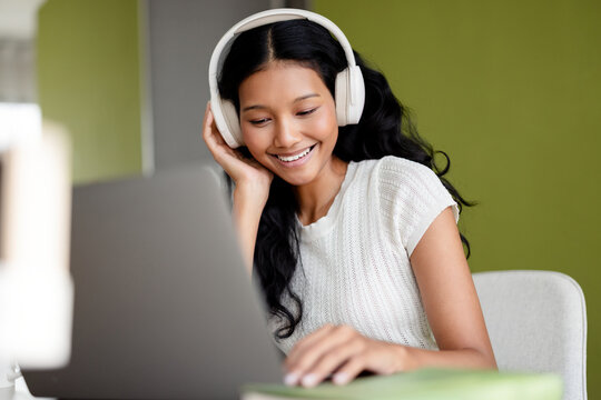 Smiling Woman With Headphones Using Laptop For Online Learning 
