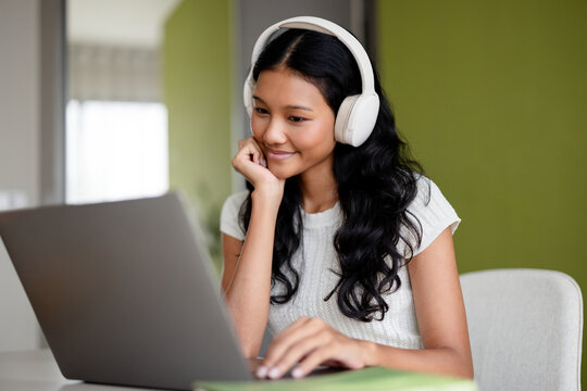 Woman With White Headphones Working On Laptop At Home Office