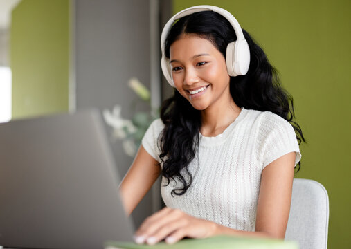 Smiling Woman With White Headphones Using Laptop At Home 