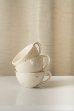 Stacked ceramic cups on white surface