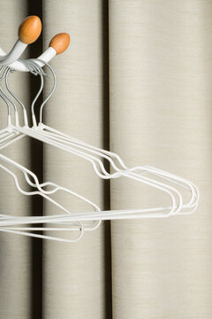 White metal hangers on beige curtain background