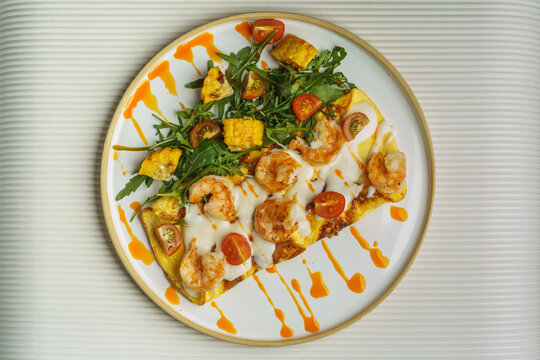 Shrimp flatbread with arugula, corn, and sauce