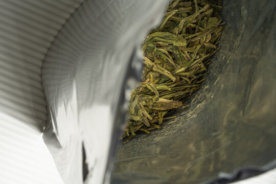 Loose green tea leaves in open pouch