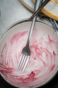  Dirty plate with fork and food remnants