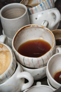 Stack of Used Coffee Cups with Leftover Drinks