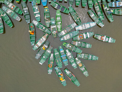 Tourist boats in tied up forming patterns around the edge of a lake