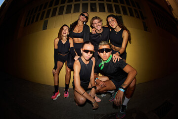 Group of friends posing in sporty outfits on a city street