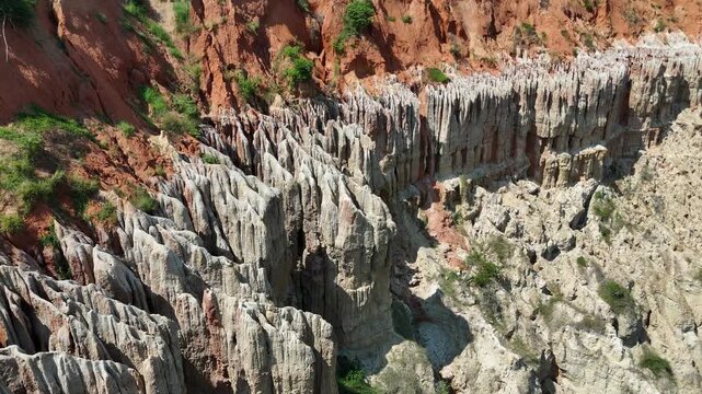 Close-up drone view of the vibrant red and orange clay pillars at the Viewpoint of the Moon Miradouro da Lua, Angola Africa aerial footage