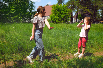 Child girl holding a point and shoot camera, photographing her sister, capture a happy moment, candid. Happy family together. Cheerful friends enjoying sunny day. Retro