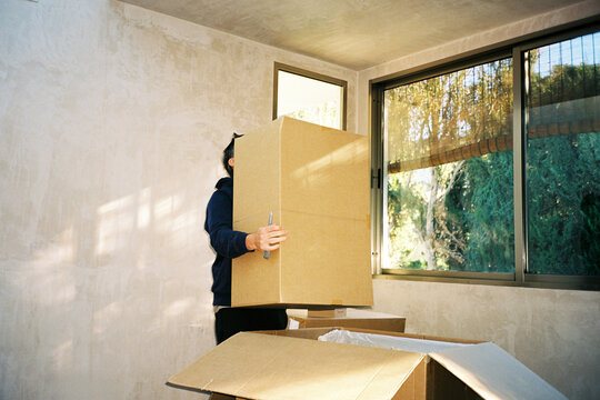 Man Carrying Large Cardboard Box
