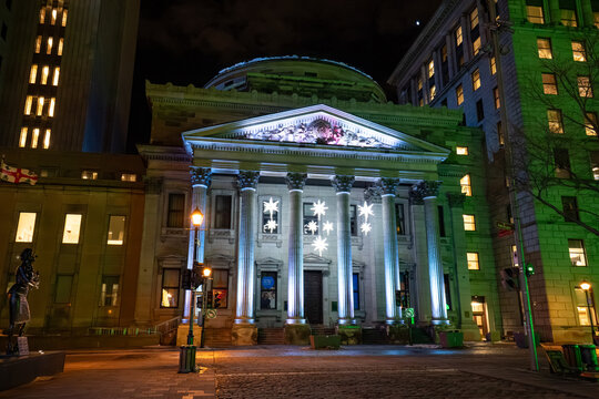 View of historic BMO Bank of Montreal building facade at night. Montreal, Canada - December 18, 2025.