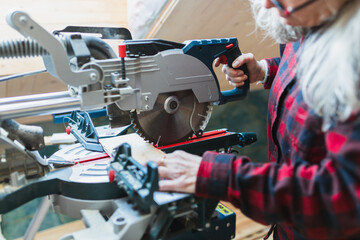 Senior Woman Using Miter Saw for Attic Renovation Project